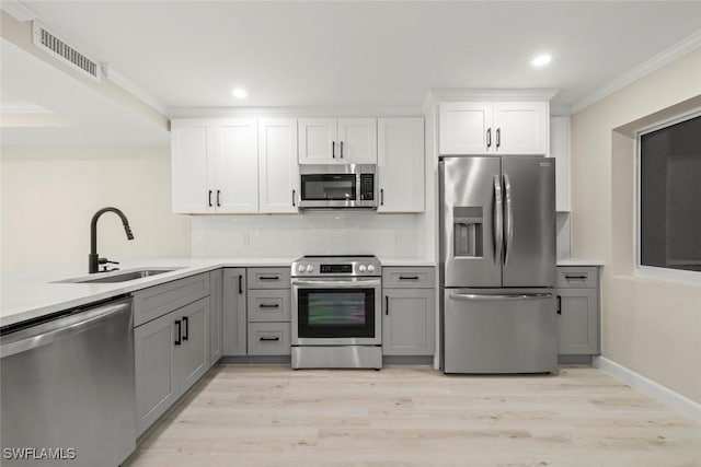 200 Periwinkle Way Unit 132, Sanibel, FL 33957 - kitchen featuring visible vents, ornamental molding, appliances with stainless steel finishes, a sink, and gray cabinetry