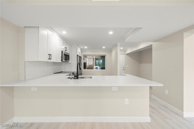 200 Periwinkle Way Unit 132, Sanibel, FL 33957 - kitchen featuring a sink, light countertops, stainless steel microwave, and a peninsula