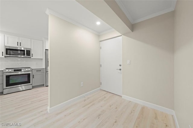 200 Periwinkle Way Unit 132, Sanibel, FL 33957 - kitchen with light wood-style flooring, appliances with stainless steel finishes, baseboards, and crown molding