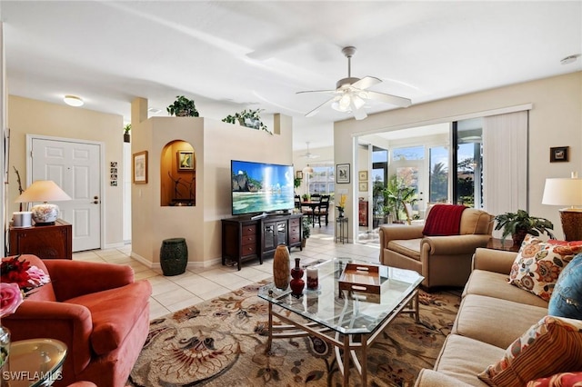 living area with light tile patterned floors, baseboards, and a ceiling fan