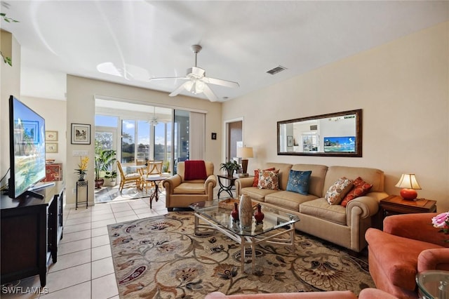 living area with light tile patterned floors, visible vents, and a ceiling fan