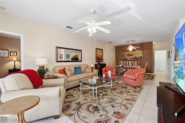 living area featuring light tile patterned floors, visible vents, and ceiling fan