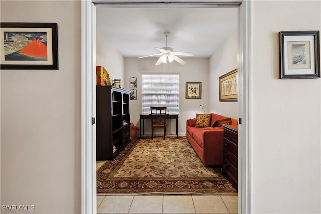 interior space with light tile patterned floors, baseboards, and ceiling fan