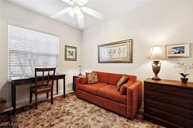 living room with baseboards and a ceiling fan