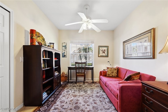 living room with baseboards and a ceiling fan