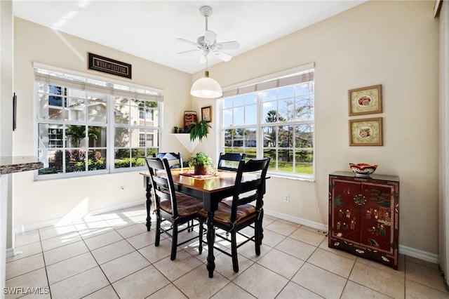 dining room featuring light tile patterned flooring, baseboards, and a ceiling fan