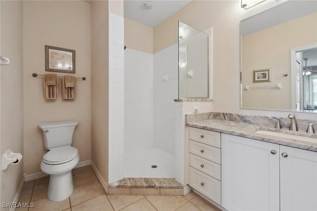 bathroom with vanity, baseboards, tile patterned flooring, a walk in shower, and toilet