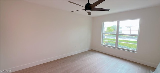 spare room with baseboards, light wood-style floors, and ceiling fan