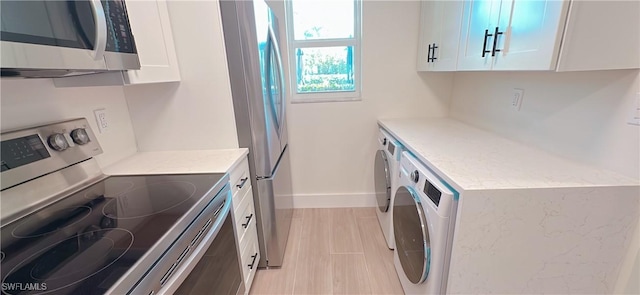 kitchen featuring washer / clothes dryer, white cabinets, stainless steel appliances, and baseboards