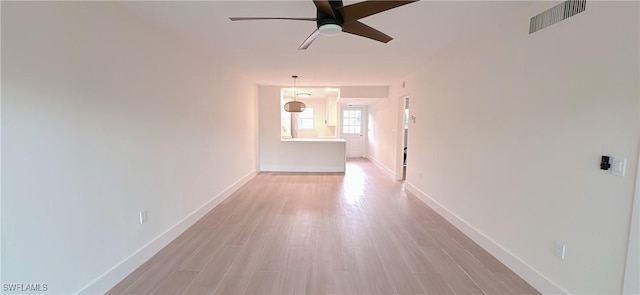 corridor with light wood-style flooring, baseboards, and visible vents