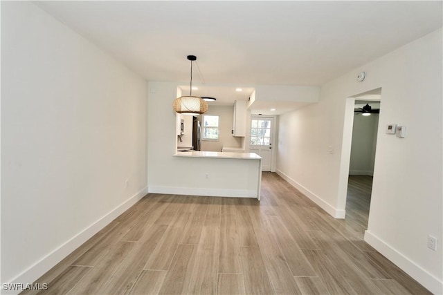 kitchen featuring baseboards and light wood finished floors