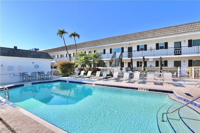 pool with a patio and fence