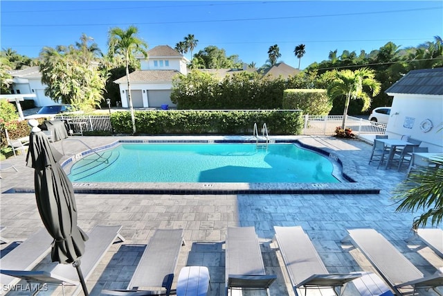 pool with a patio area and fence