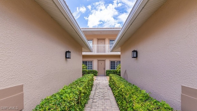 doorway to property featuring stucco siding and a balcony