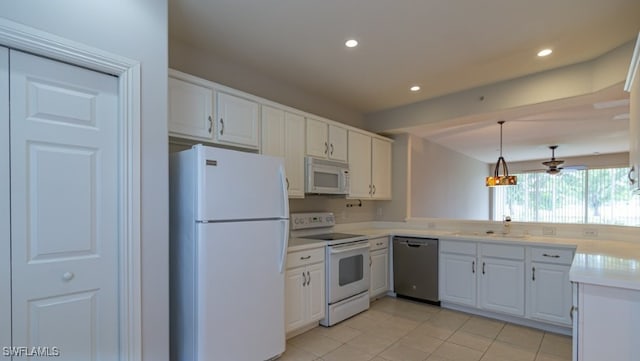 kitchen featuring white appliances, recessed lighting, light countertops, white cabinetry, and decorative light fixtures