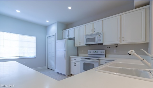 kitchen with light countertops, recessed lighting, white appliances, white cabinetry, and a sink