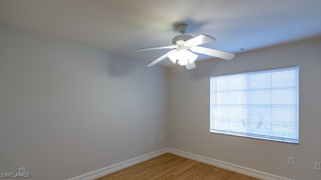 unfurnished room with a ceiling fan, light wood-style floors, and baseboards