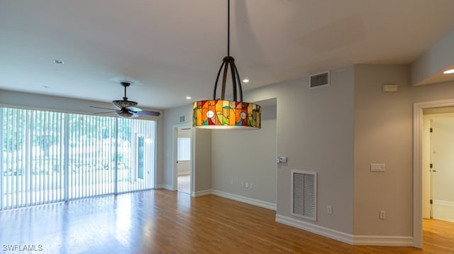 interior space featuring visible vents, ceiling fan, baseboards, and wood finished floors