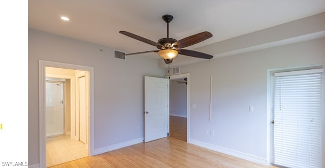 unfurnished bedroom featuring visible vents, ensuite bath, light wood-type flooring, and baseboards