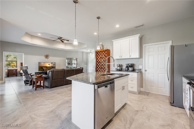 kitchen featuring dark stone countertops, visible vents, a sink, appliances with stainless steel finishes, and a raised ceiling