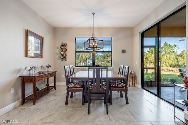 dining space featuring an inviting chandelier, plenty of natural light, and baseboards