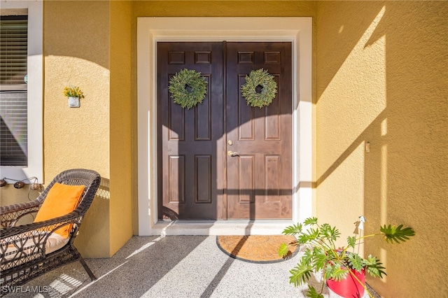 doorway to property featuring stucco siding