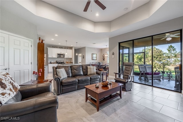 living area featuring recessed lighting, baseboards, and a ceiling fan