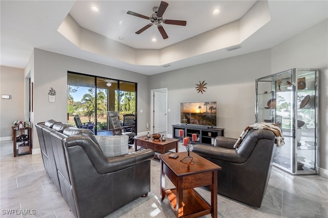 living area featuring visible vents, a raised ceiling, a ceiling fan, recessed lighting, and baseboards