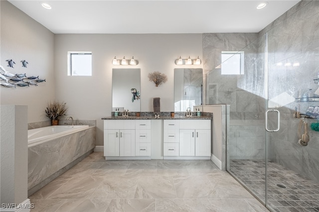 bathroom featuring a stall shower, vanity, and a garden tub