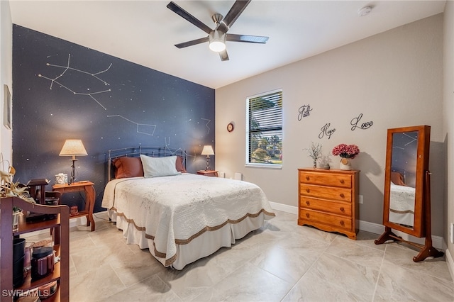 bedroom featuring baseboards, ceiling fan, and an accent wall