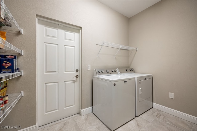 washroom featuring washer and dryer, laundry area, baseboards, and marble finish floor