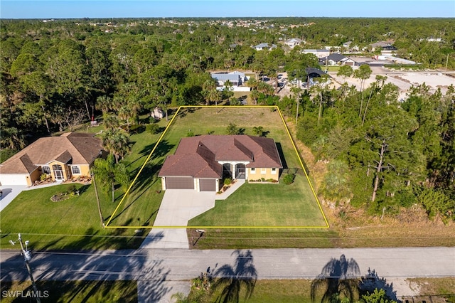 birds eye view of property featuring a forest view