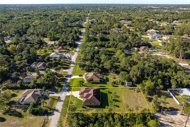 drone / aerial view with a residential view and a view of trees