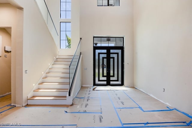 entryway featuring stairway and a high ceiling