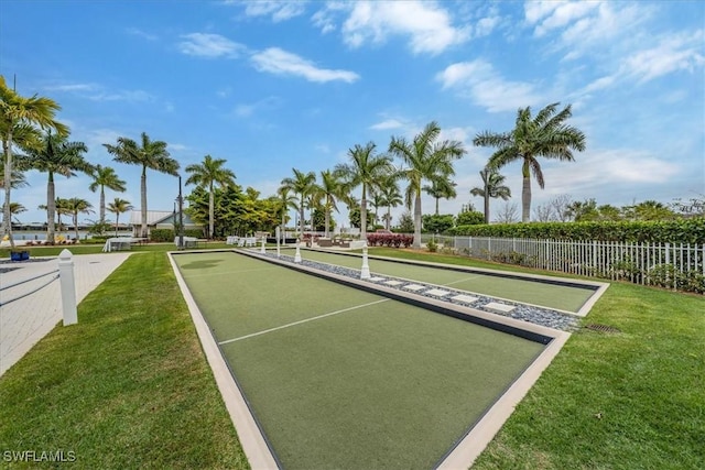 view of community featuring a yard and fence