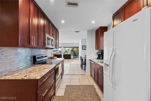 2032 Bahama Ave, Fort Myers, FL 33905 - kitchen with light stone counters, tasteful backsplash, appliances with stainless steel finishes, light tile patterned floors, and visible vents