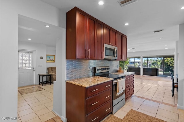 2032 Bahama Ave, Fort Myers, FL 33905 - kitchen with decorative backsplash, stainless steel appliances, reddish brown cabinets, and visible vents