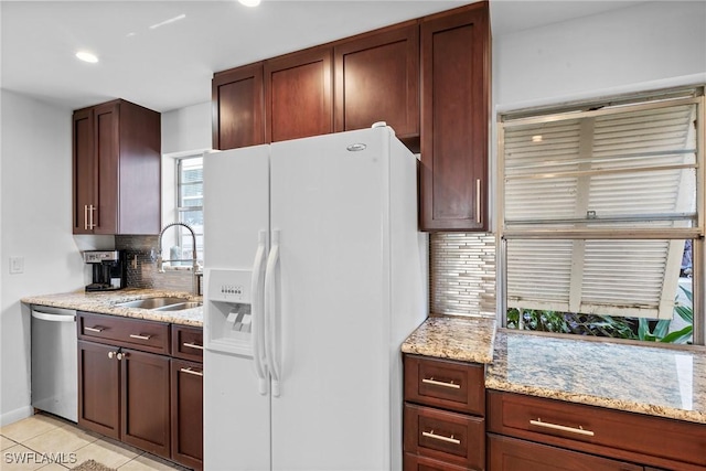 2032 Bahama Ave, Fort Myers, FL 33905 - kitchen with light tile patterned flooring, backsplash, white fridge with ice dispenser, a sink, and stainless steel dishwasher