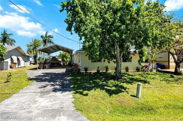 2032 Bahama Ave, Fort Myers, FL 33905 - view of front facade with central air condition unit, a detached carport, concrete driveway, and a front yard