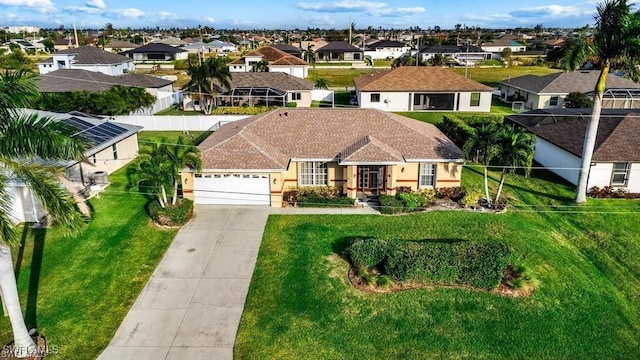 view of front of home with concrete driveway, a garage, a residential view, and a front yard