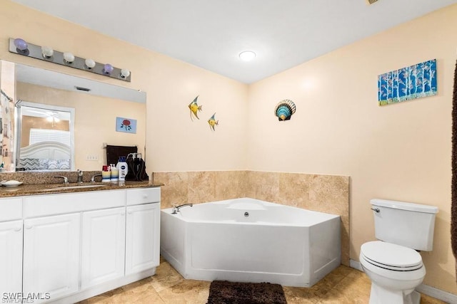 bathroom with vanity, a garden tub, toilet, and ensuite bathroom