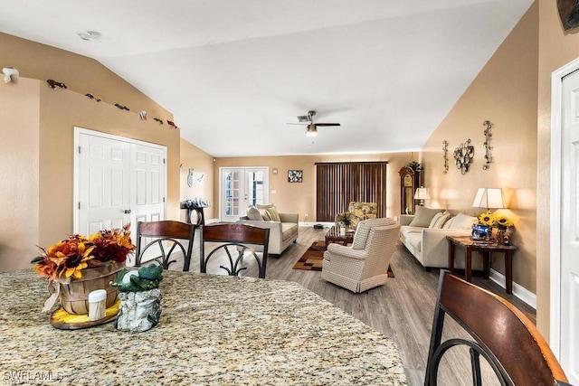 dining area featuring ceiling fan, baseboards, lofted ceiling, and wood finished floors