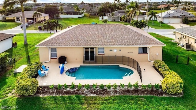 view of swimming pool featuring a yard, a residential view, a fenced in pool, and a fenced backyard