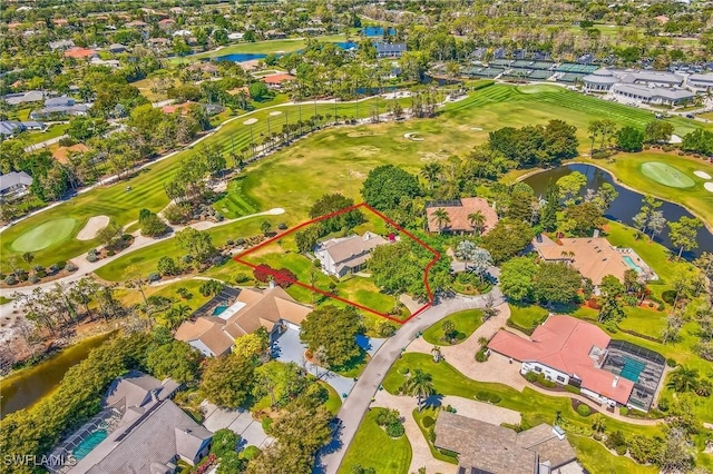 drone / aerial view with a residential view, golf course view, and a water view