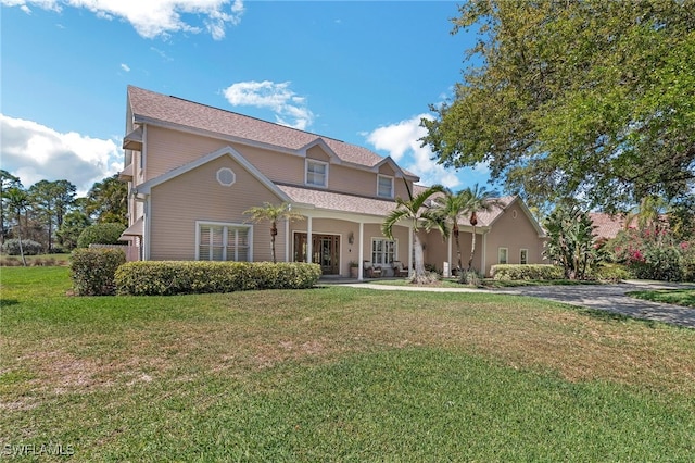 traditional home featuring covered porch and a front yard