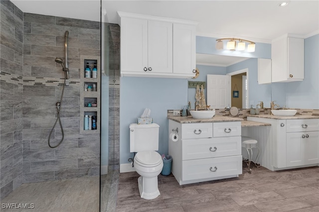 full bathroom featuring vanity, toilet, crown molding, and a walk in shower