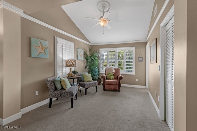 sitting room with baseboards, lofted ceiling, ornamental molding, carpet flooring, and a ceiling fan