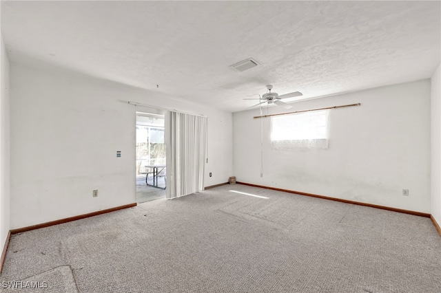 empty room featuring carpet floors, baseboards, a wealth of natural light, and a textured ceiling