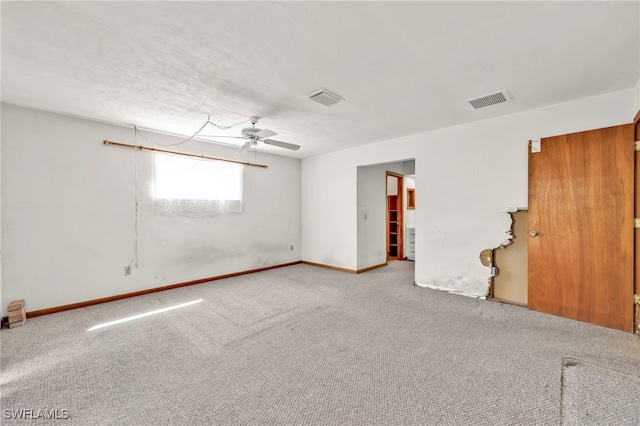 carpeted empty room featuring a ceiling fan, visible vents, and baseboards