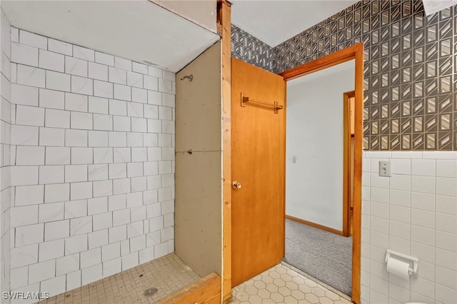 bathroom featuring tile patterned flooring, a shower stall, and tile walls